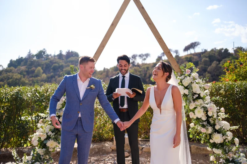 Pareja de novios sonriendo durante la ceremonia de su boda en malaga al aire libre