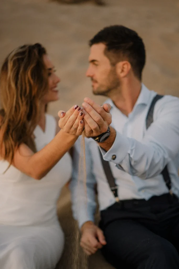 Pareja disfrutando haciéndose fotos en la arena en sesion postboda malaga