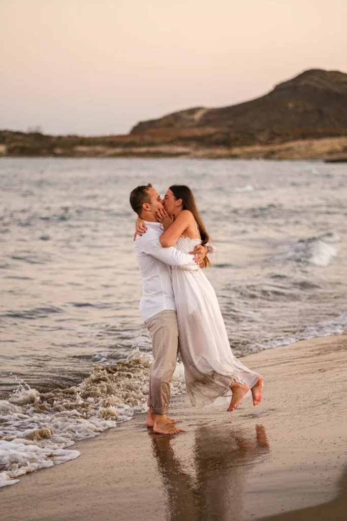 Jose está cogiendo a Marina en Brazos, un momento de su Preboda en Cabo de Gata, Almería.
