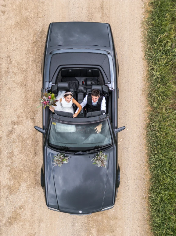 Vista aérea de los novios montados en el coche.