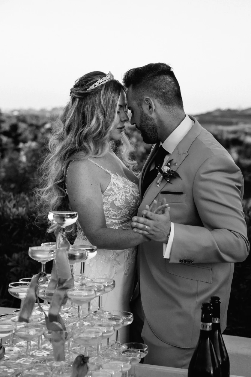 Los novios y la torre de copas de champagne.